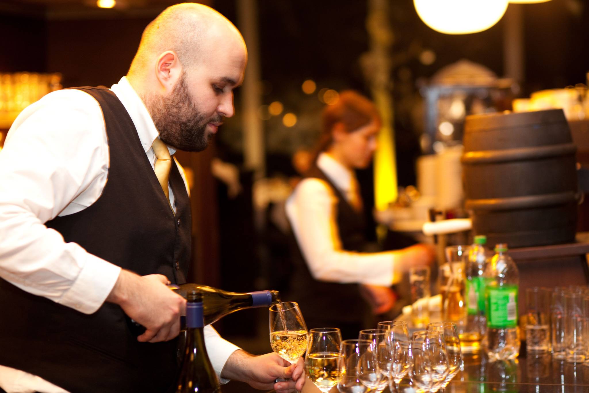 Kellner gießt Wein ein