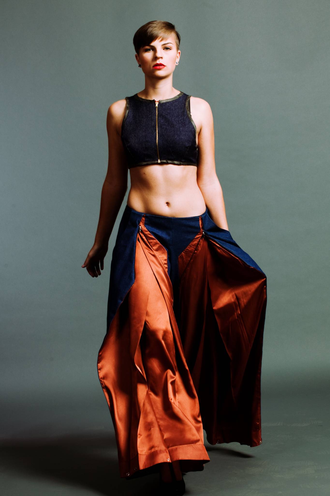 Model in bauchfreiem Oberteil, Schlaghose, gehend