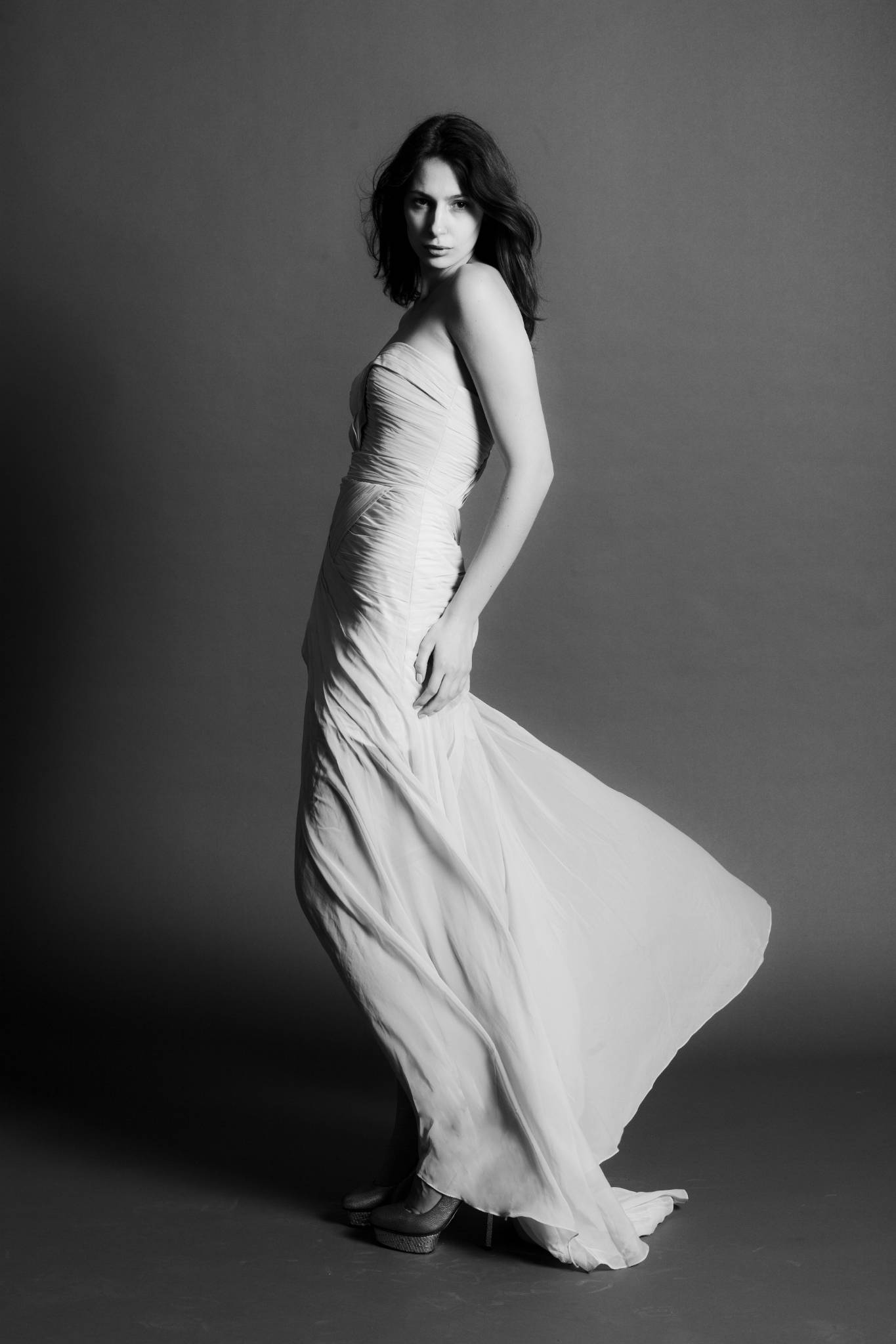 Model im weißen Kleid, Studiowand